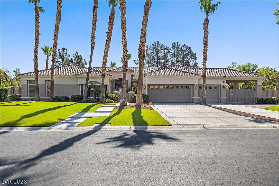 Front elevation viewed straight on: a single-story Mediterranean with tile roof, gated courtyard, and rhythmic palm columns.